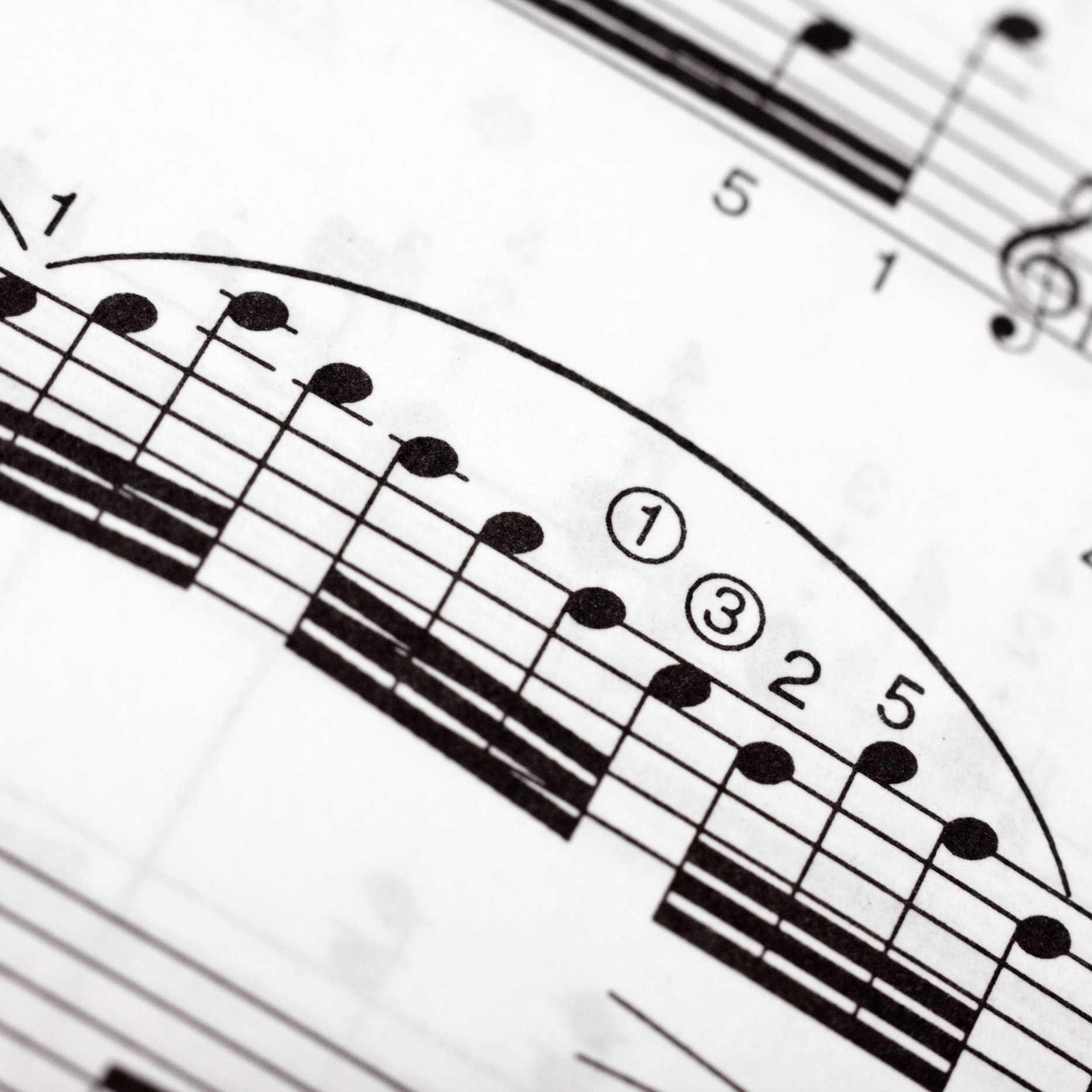 Groups of fast musical notes with a large legato arch over them on a music sheet, as part of a classical piece
