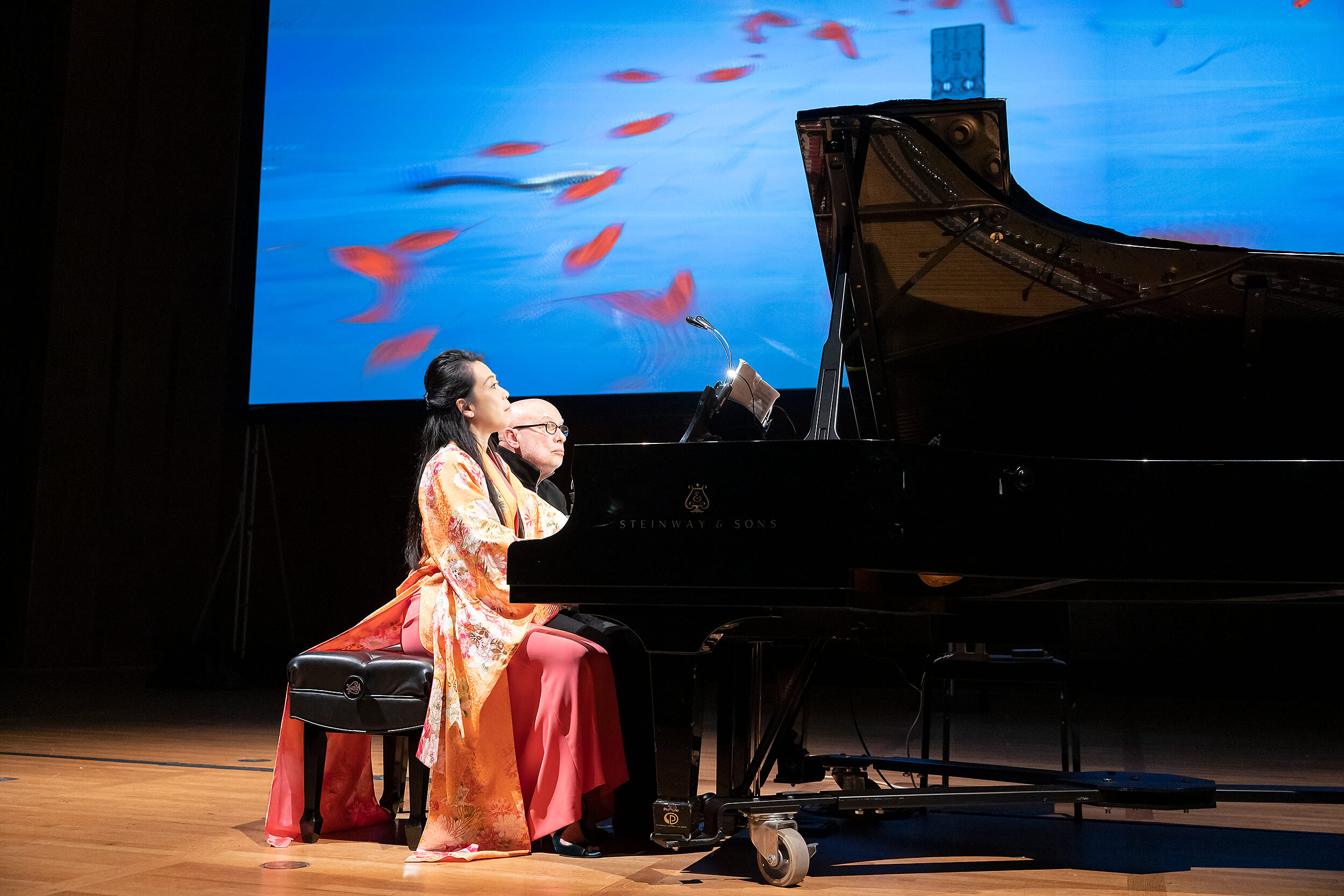 Maki Namekawa and Dennis Russell Davies playing piano