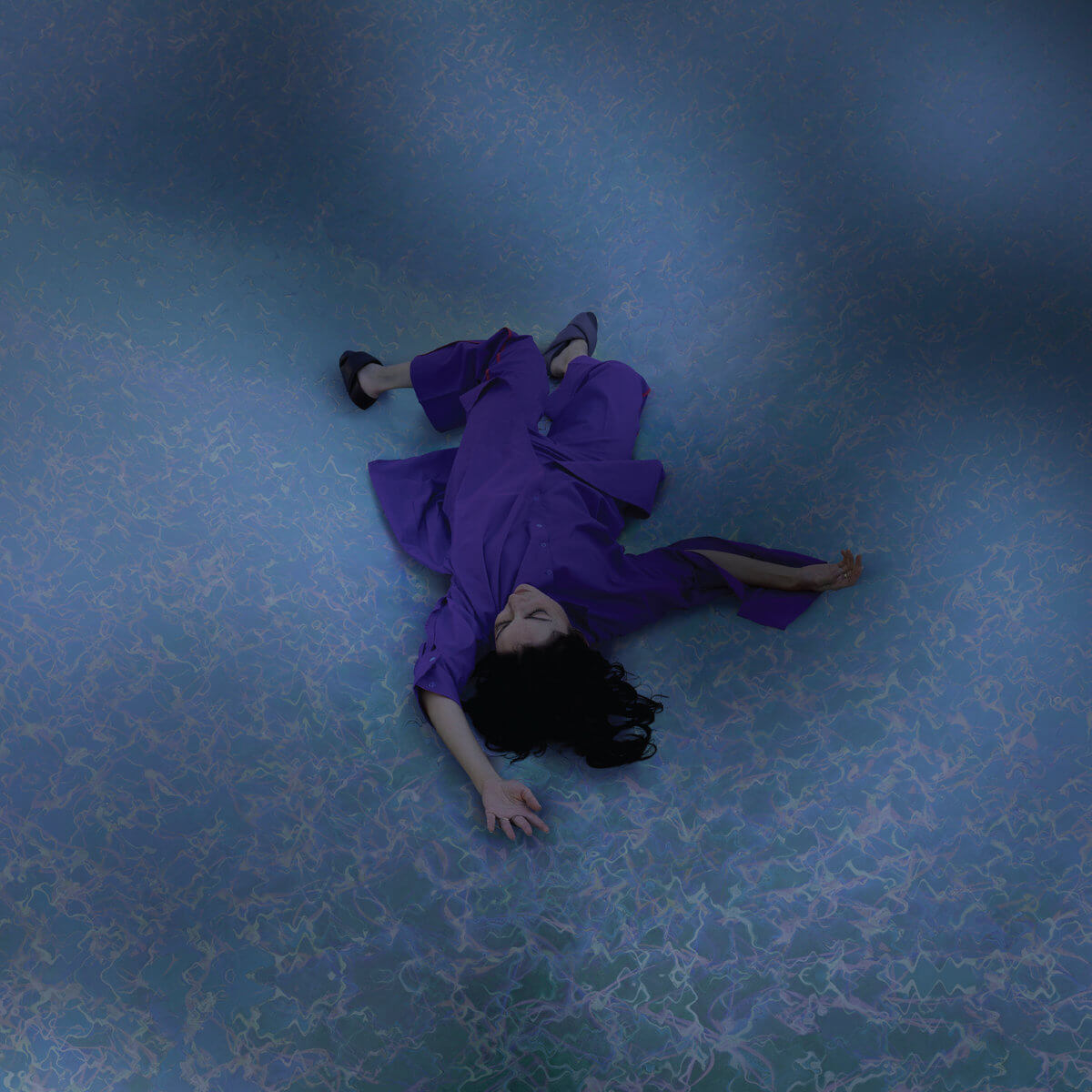 A woman in a blue lying on a light blue floor.