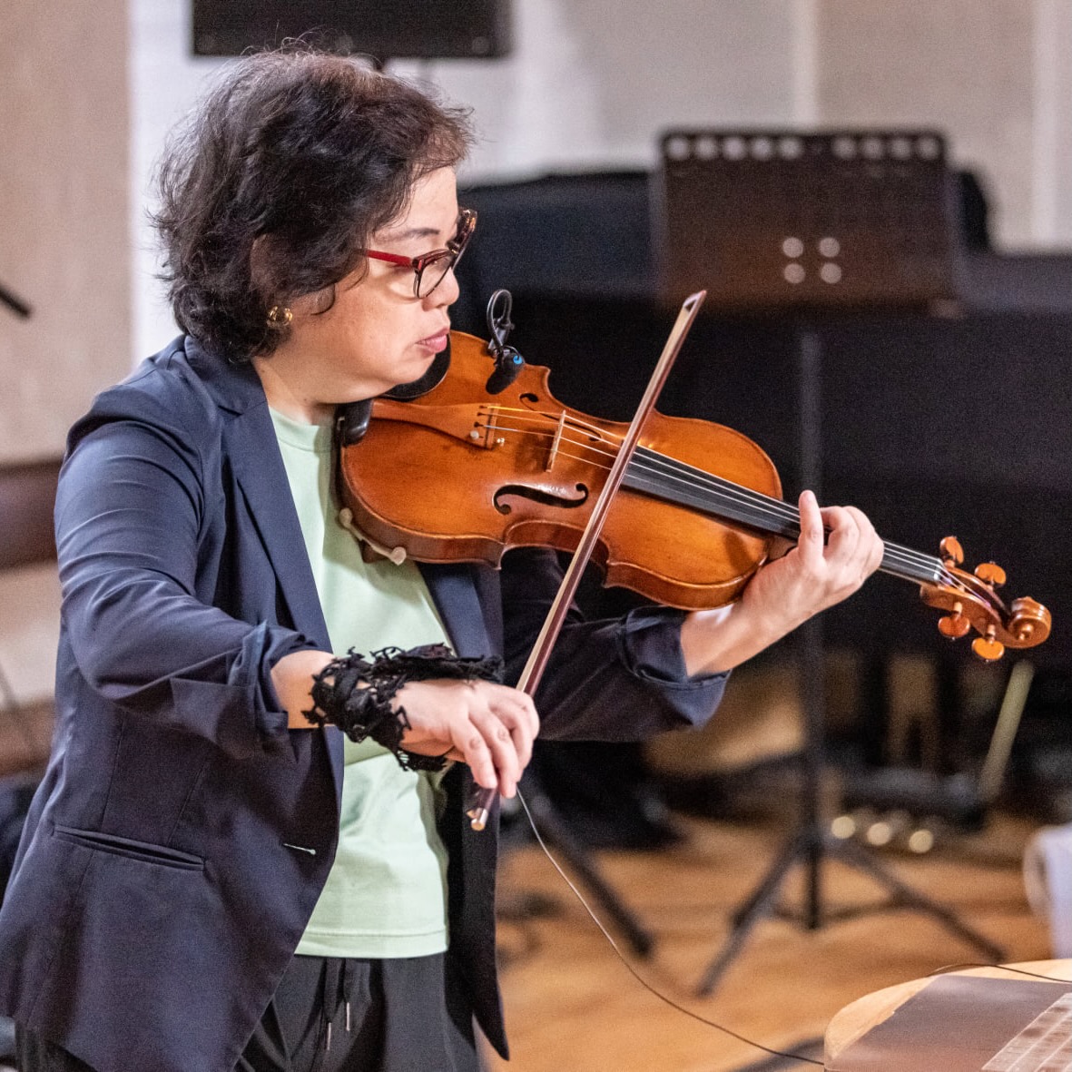 Mari Kimura plays a violin with a motion sensor strapped to her bow hand.