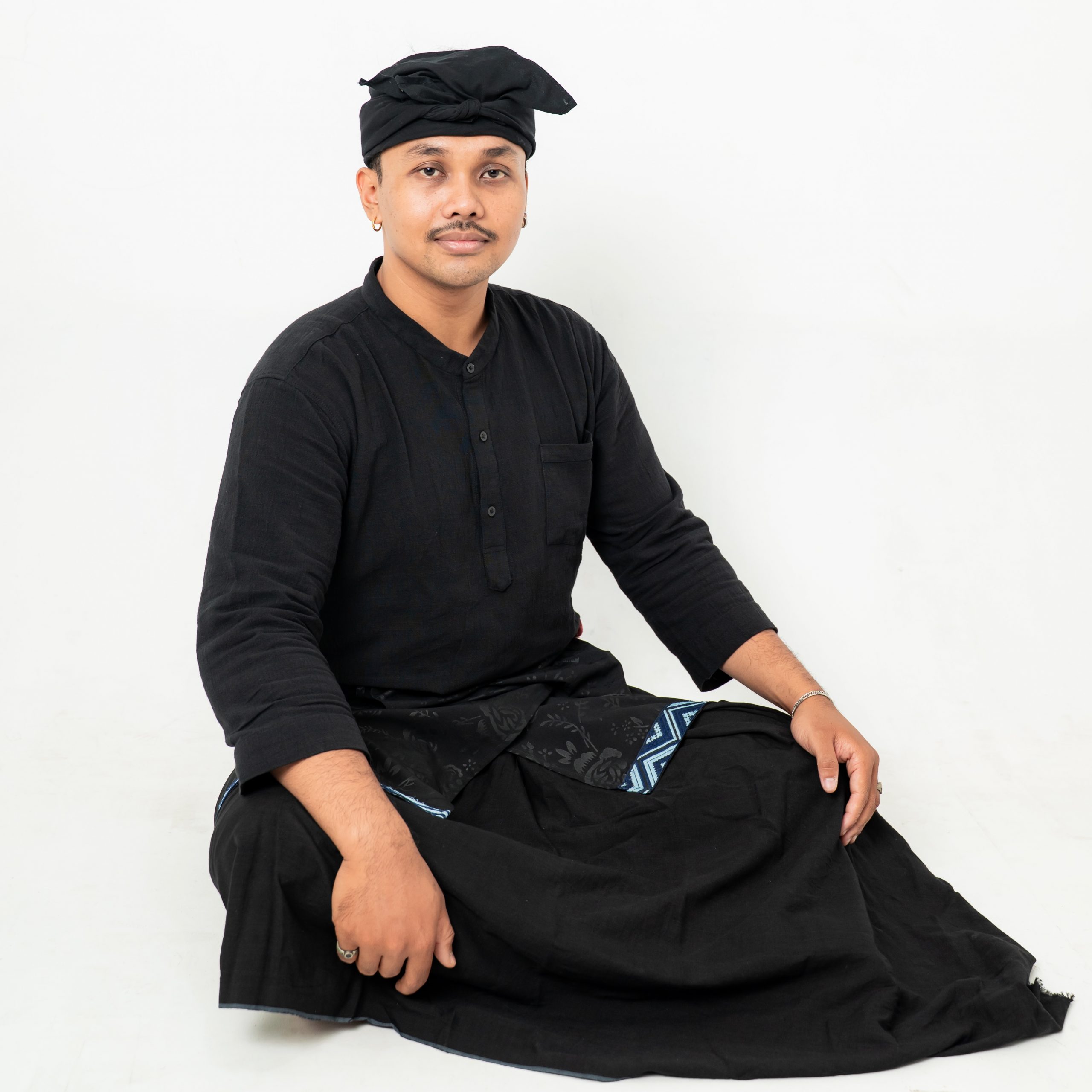 I Kadek Janurangga. Photo by Wah Photo. I Kadek Janurangga posing for a photo wearing black with a white background.