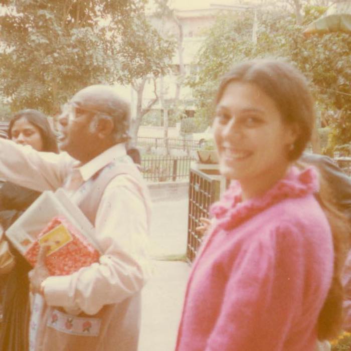 A man looking to the left and a smiling woman in pink looking at the camera.