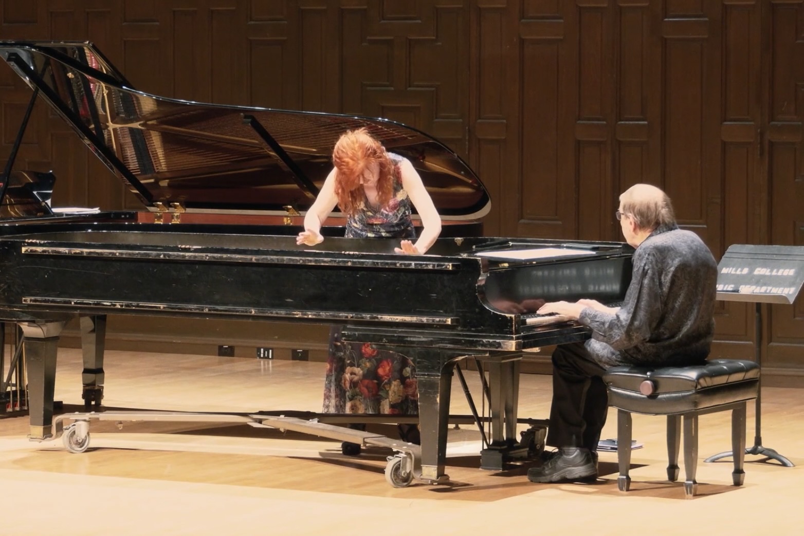 Sarah Cahill and Joseph Kubera A woman reaching in to a piano while a man plays it.