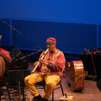 William Parker playing a large wooden flute.