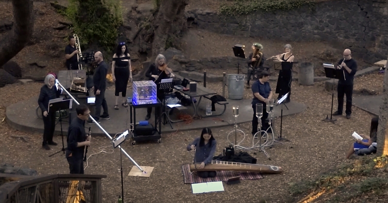 Large ensemble performing outdoors.