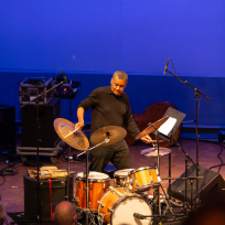 Donald Robinson playing drums standing up.