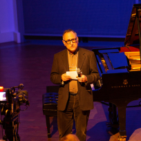 Harry Bernstein speaking on stage.